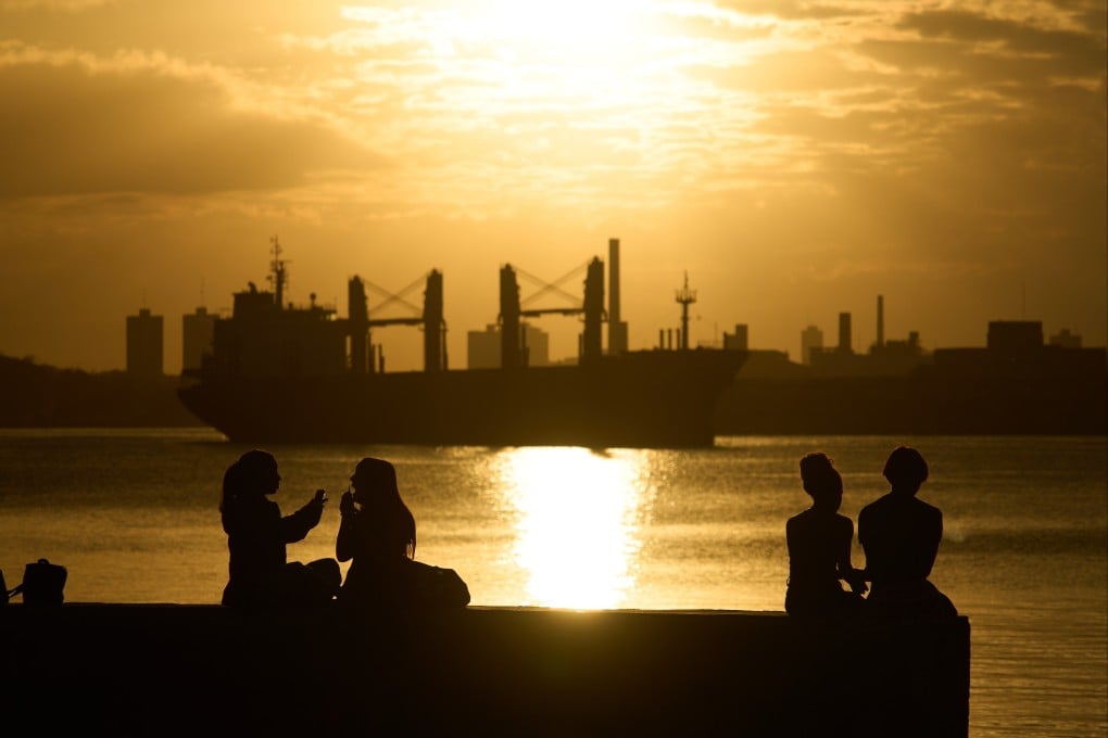 People sit on the seawall in Regla, Cuba, across the bay from Havana. Photo: AP