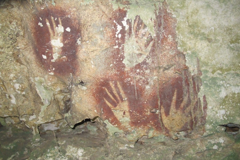 Handprints with sharpened fingertips on a cave wall in the Maros region of Sulawesi, Indonesia. Photo: Ahdi Agus Oktaviana/Maxime Aubert/AP