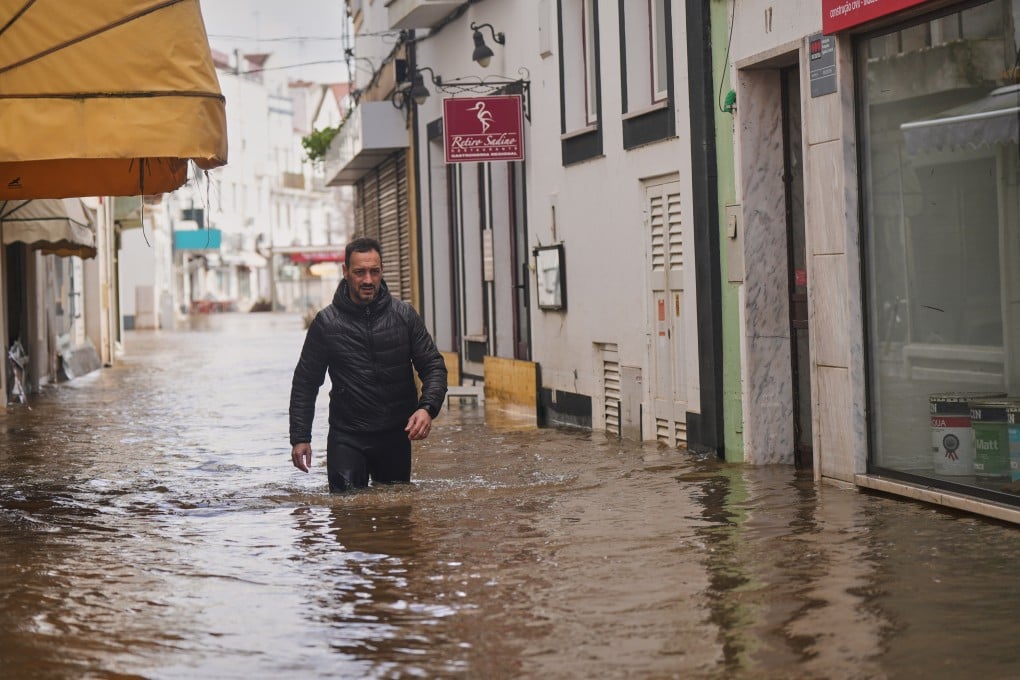 A resident walks along a flooded street after the Sado River overflowed following heavy rains in Alcácer do Sal, southern Portugal, on Friday. Photo: AP