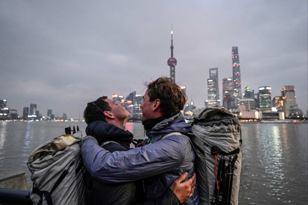 Loic Voisot (right) and Benjamin Humblot embrace on Shanghai’s Bund promenade on Saturday, marking the end of their remarkable walk from France to China. Photo: AFP