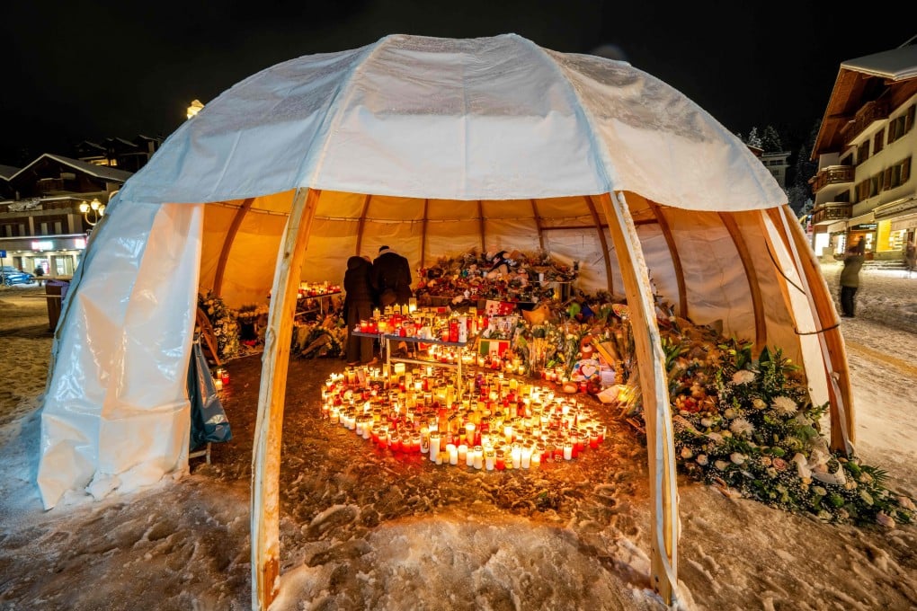 Mourners place messages, candles, and flowers at a memorial outside Le Constellation bar during a national day of mourning in Crans-Montana, Switzerland on January 9. Photo: AFP
