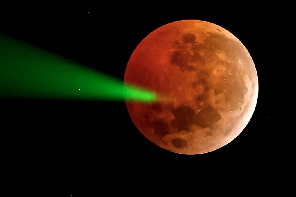 A full moon eclipse being targeted with a laser from the Foster Observatory telescope in Santiago, Chile in 2025. Photo: AFP