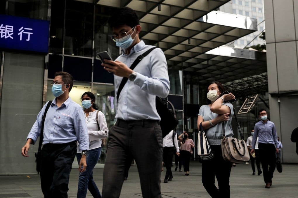 Office workers walk through the financial district of Singapore, in February 2021. Photo: EPA-EFE
