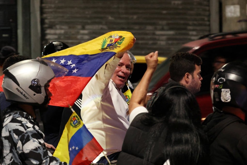 Juan Pablo Guanipa waves a Venezuelan flag outside the Helicoide detention centre on Sunday. Photo: Reuters