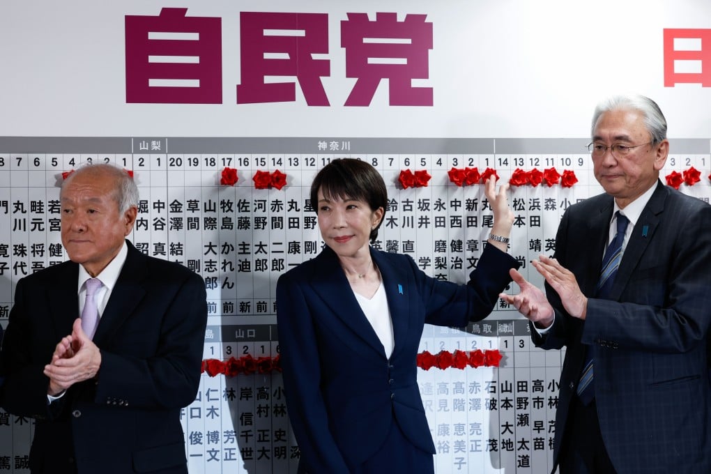 Japanese Prime Minister Sanae Takaichi (centre), leader of Japan’s ruling Liberal Democratic Party, places flowers symbolising success onto the names of candidates at the party’s headquarters in Tokyo on February 8, 2026. Photo: Xinhua