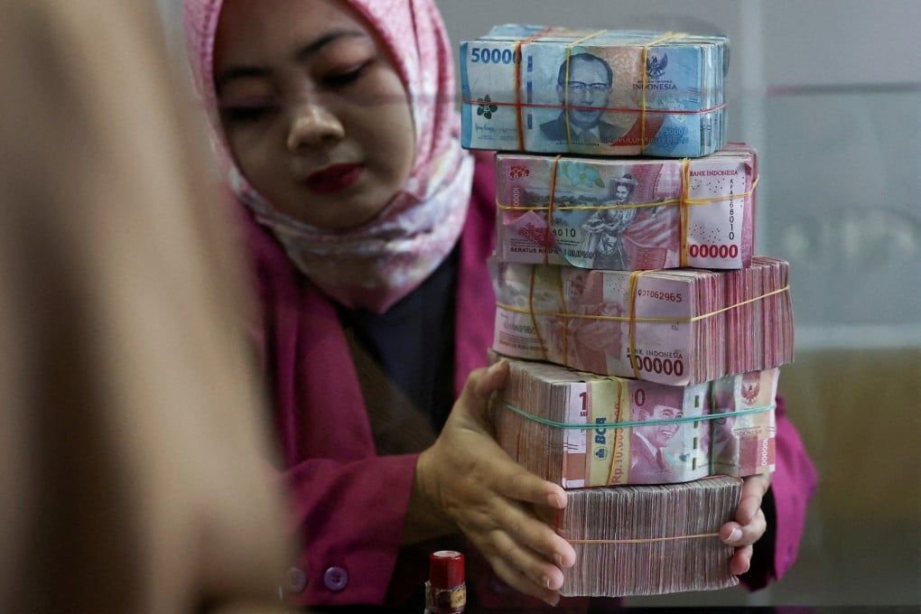 A teller prepares rupiah bank notes at a money changer in Jakarta, Indonesia, on April 9, 2025. The Southeast Asian nation has one of the world’s largest populations without access to banking services. Photo: Reuters