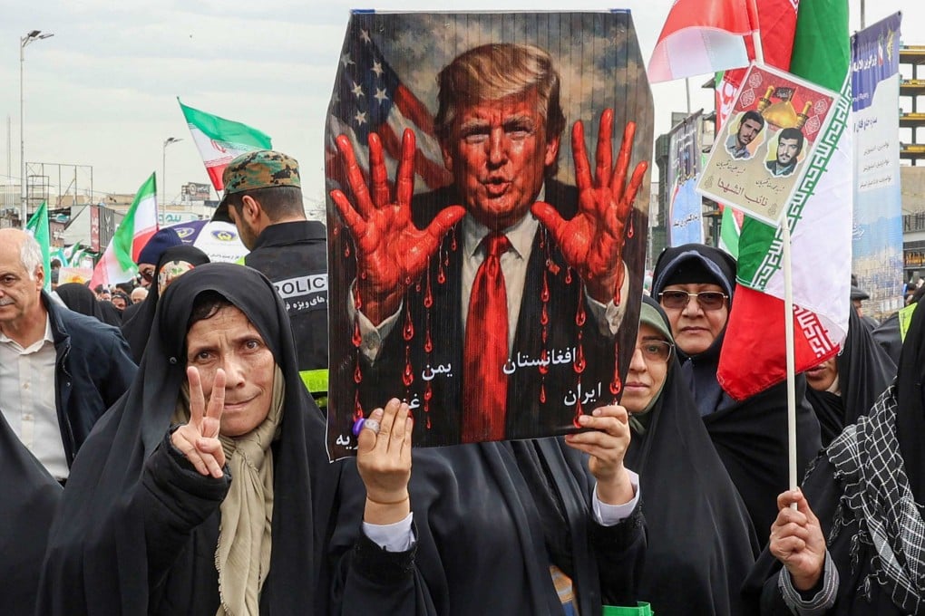 Women march with a sign depicting US President Donald Trump with bloodied hands in Tehran on Wednesday during a rally marking the anniversary of the 1979 Islamic revolution. Photo: AFP