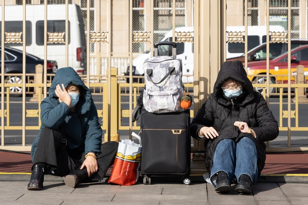 Travelers wait with their luggage outside a train station in Beijing on February 10, 2026. Photo: EPA