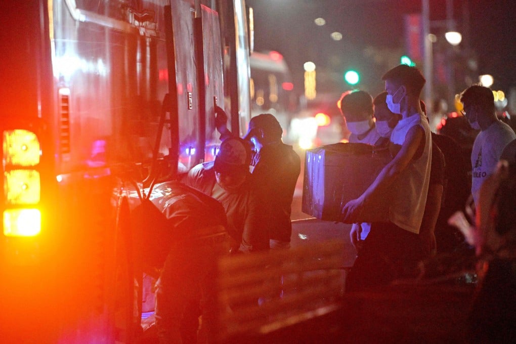 People carry their belongings onto a bus as they leave a suspected scam centre compound in Sihanoukville, Cambodia, last month. Photo: AFP