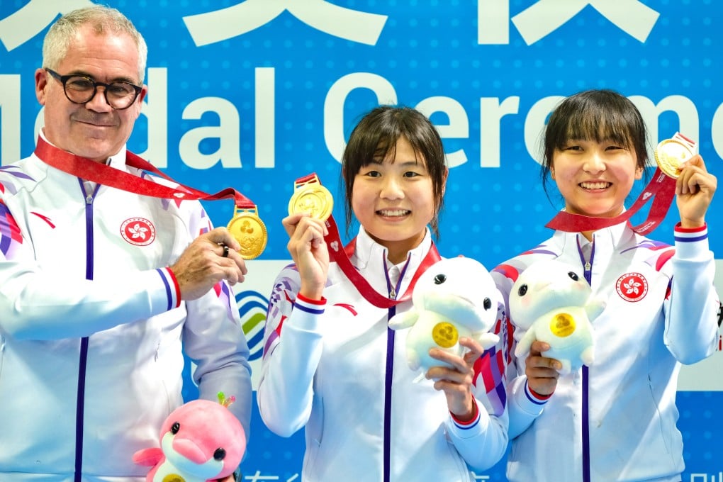 Herve Dagorne with leading cyclists Chloe Leung (centre) and Ceci Lee after the pair’s National Games Madison gold. Photo: Karma Lo