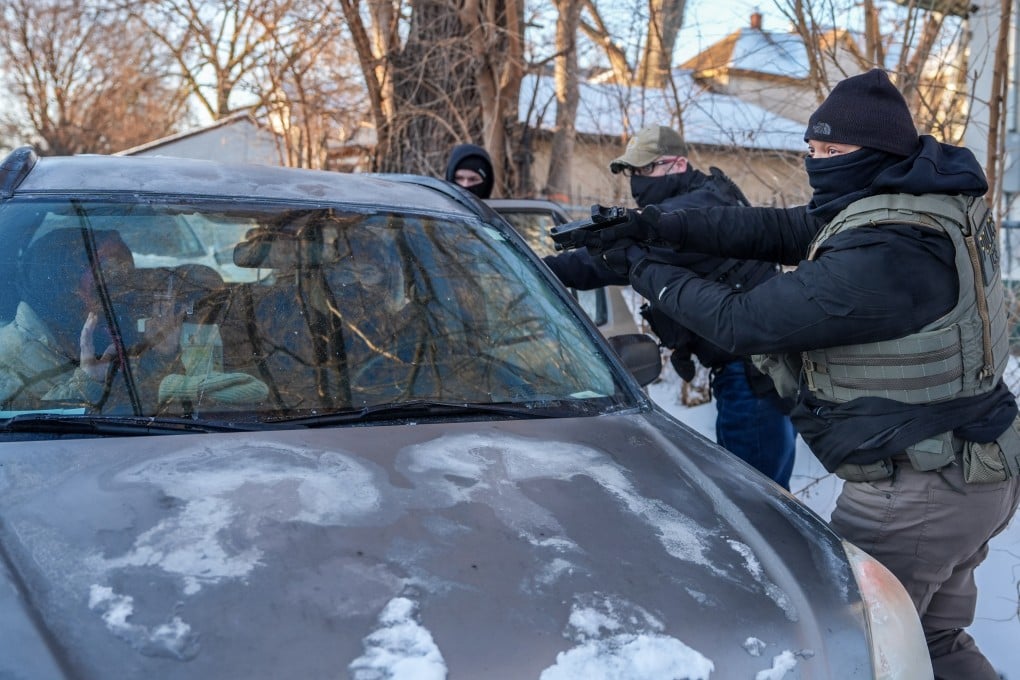 A federal agent brandishes a firearm at activists for following agents’ vehicles in Minneapolis. Photo: AP