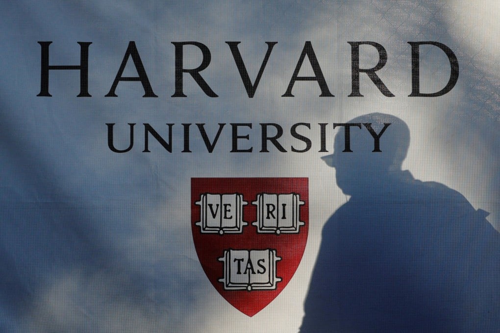 A pedestrian casts a shadow on a Harvard University sign in Cambridge, Massachusetts, in September 2025. Photo: Reuters