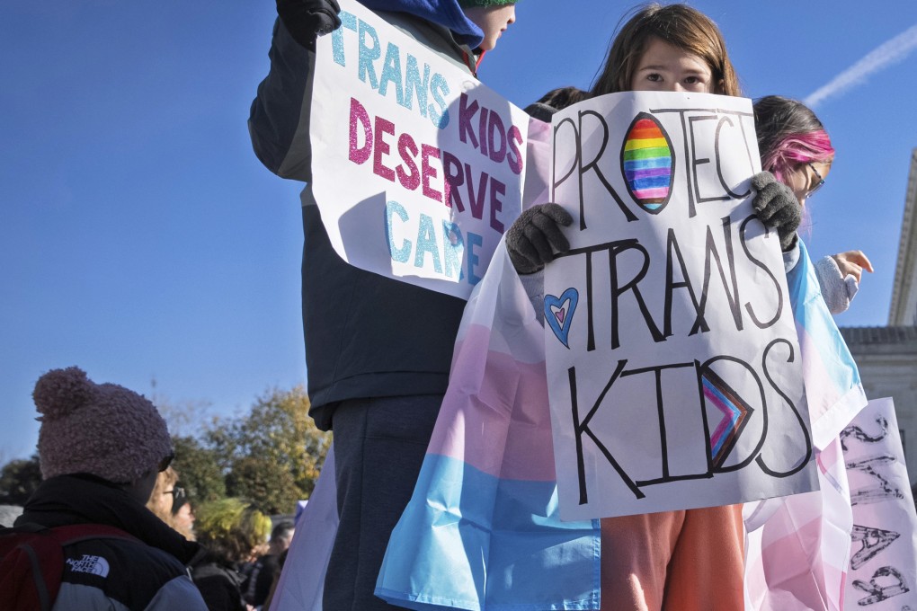 Children hold signs and transgender pride flags during a transgender rights rally in 2024 in Washington. Photo: AP