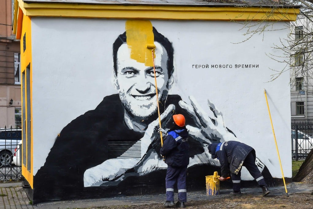 A worker paints over graffiti of jailed Kremlin critic Alexei Navalny in St Petersburg in April 2021. The inscription reads: “The hero of the new times.” Photo: AFP