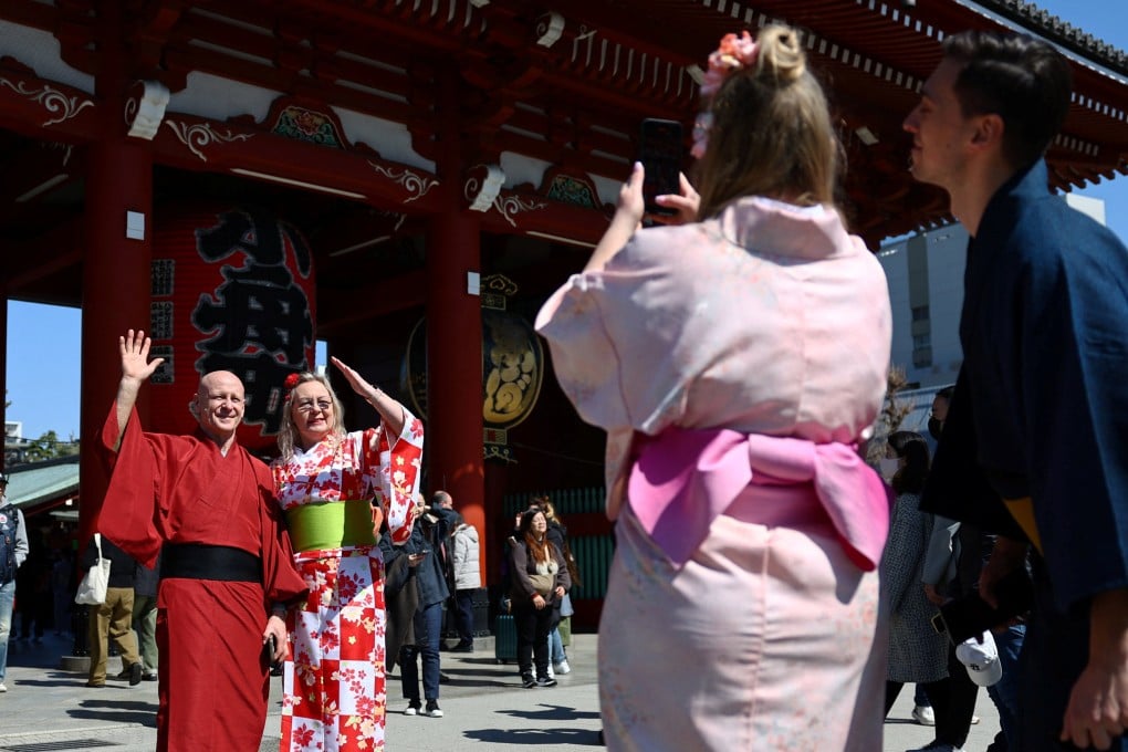 Foreign tourists wearing Japanese traditional kimono clothes pose for a photograph near Sensoji temple at Asakusa district, a popular sightseeing spot in Tokyo. Photo: Reuters