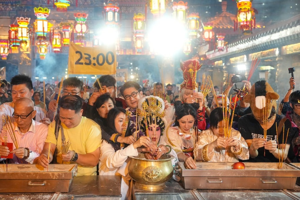 Worshippers including veteran actress Lana Wong (centre) offer incense sticks at Wong Tai Sin Temple. Photo: Sam Tsang