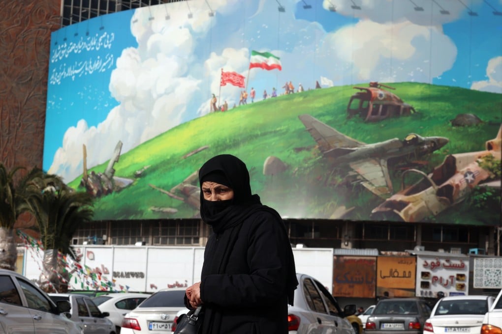 An Iranian woman walks past an anti-US billboard in Tehran, Iran. Photo: EPA