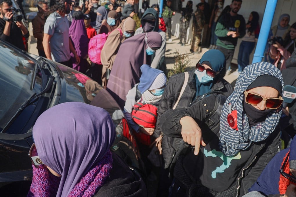 Australian family members of suspected Isis militants walk toward a van bound for the airport during the first repatriation operation of the year at Roj Camp in eastern Syria on Monday. Photo: AP