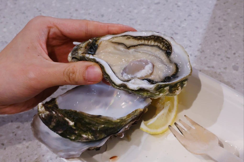 A diner eats fresh oysters at a food court in Causeway Bay on February 14. Photo: Nora Tam