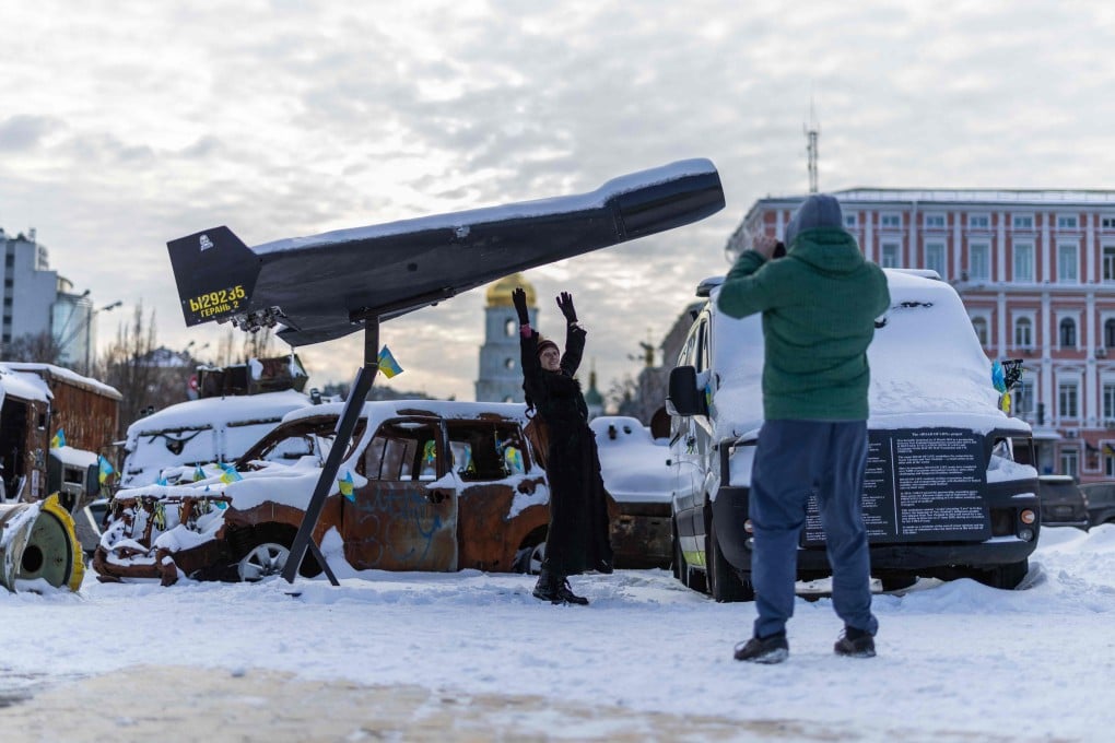 A woman poses underneath a downed Shaded drone at an exhibition of Russian military equipment in Kyiv, Ukraine, on Tuesday. Photo: AFP