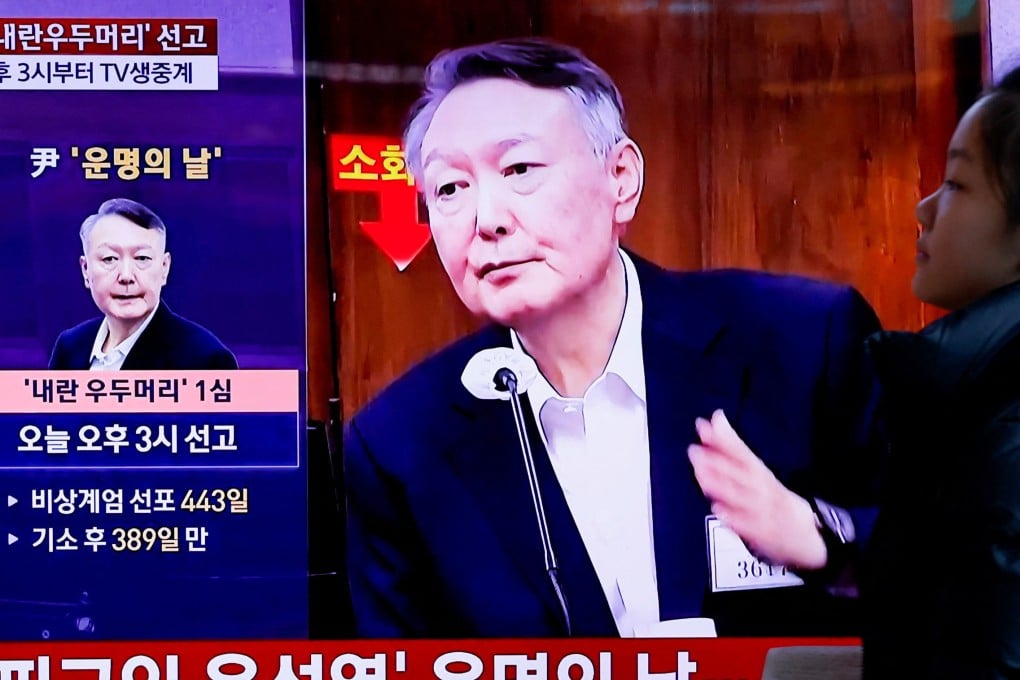 A woman walks past a television screen in Seoul broadcasting a news report on Yoon Suk-yeol’s sentencing on Thursday. Photo: Reuters