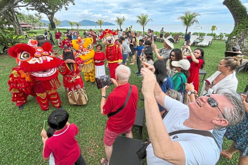 Tourists pose with lion dancers during the Lunar New Year celebrations in Penang, Malaysia. Photo: The Star
