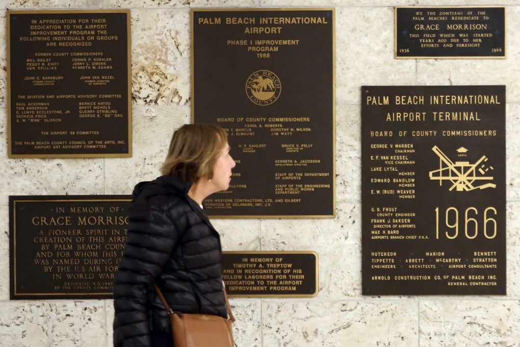 A passenger walks past signage for the Palm Beach International Airport. Photo: TNS