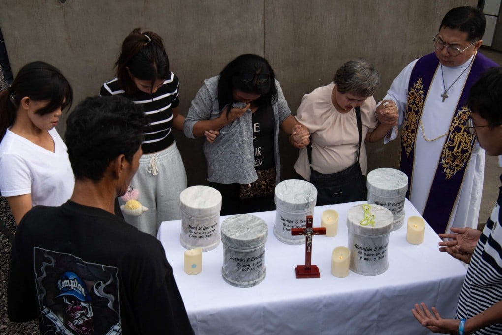 Catholic priest Flavie Villanueva (right) joins hands with relatives of those killed in former Philippine president Rodrigo Duterte’s drug war during inurnment rites on Friday. Photo:  AFP