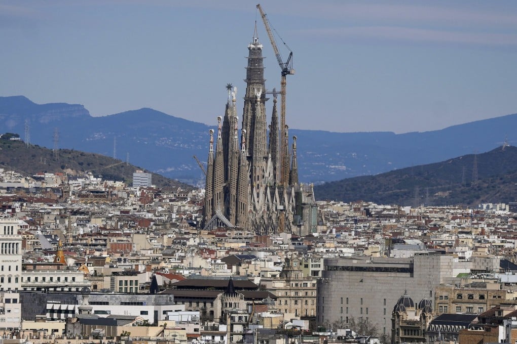 A crane places the upper arm of the cross onto the central tower of the Sagrada Familia  in Barcelona on Friday. Photo: EPA