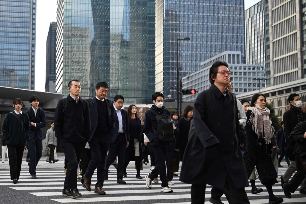 People cross a road in Tokyo, Japan. Government reforms over the past two decades had helped reduce average working hours. Photo: AFP