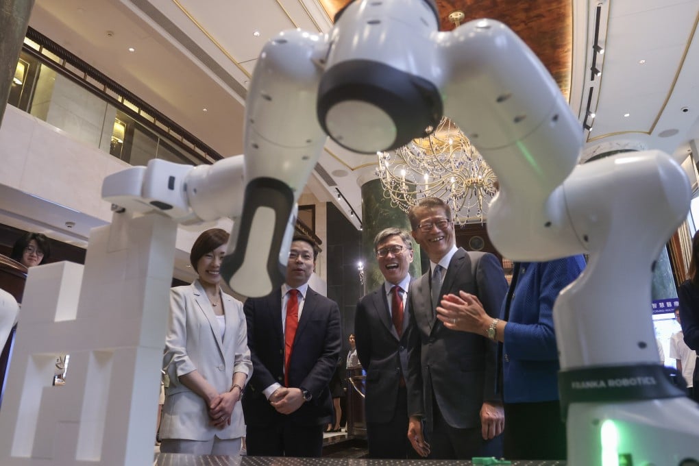 Paul Chan (right) is given a robot technology demonstration. Photo: Jonathan Wong