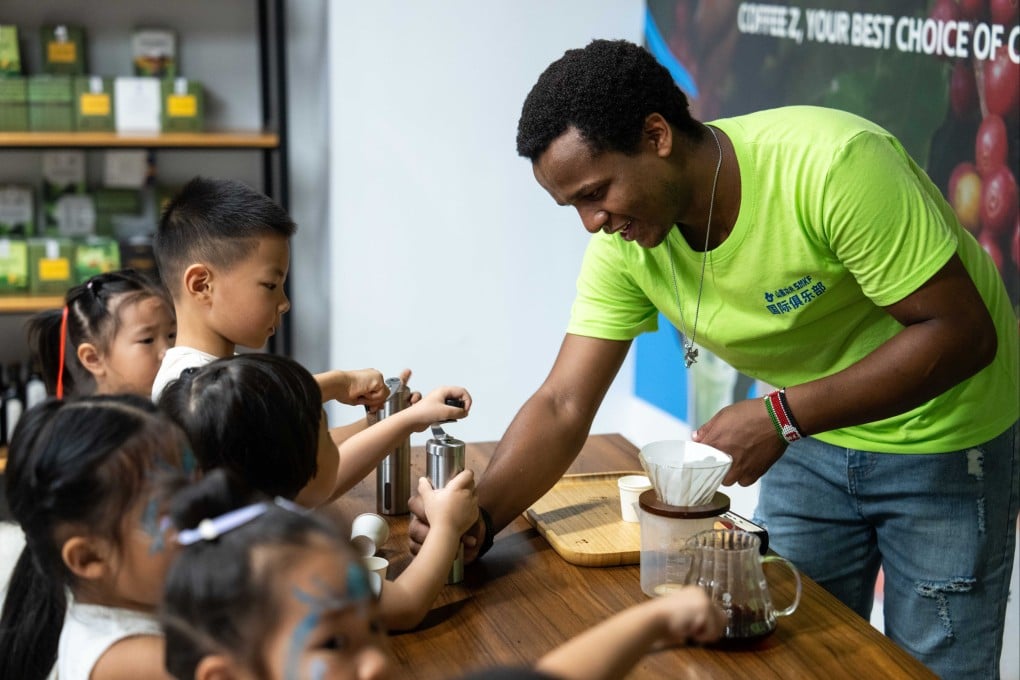 A volunteer grinds coffee beans with children during a hands-on experience session at the Ethiopian pavilion of the China-Africa Economic and Trade Cooperation Promotion Innovation Demonstration Park in Changsha,  Hunan province on August 30, 2024. Photo: Xinhua