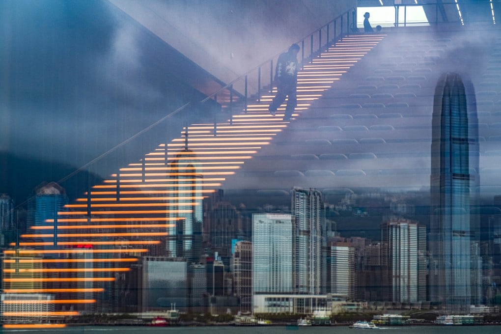 A man walks on illuminated stairs at M+ Museum in West Kowloon as Hong Kong’s skyline is seen in a reflection on May 28, 2025. Photo: Eugene Lee