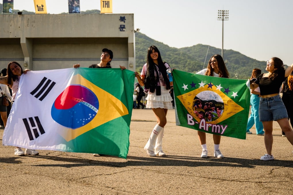 BTS fans who flew from Brazil to see the K-pop super act’s members Jungkook and Jimin released from military service pose with flags in Yeoncheon, South Korea, on June 11 last year. Photo: AFP