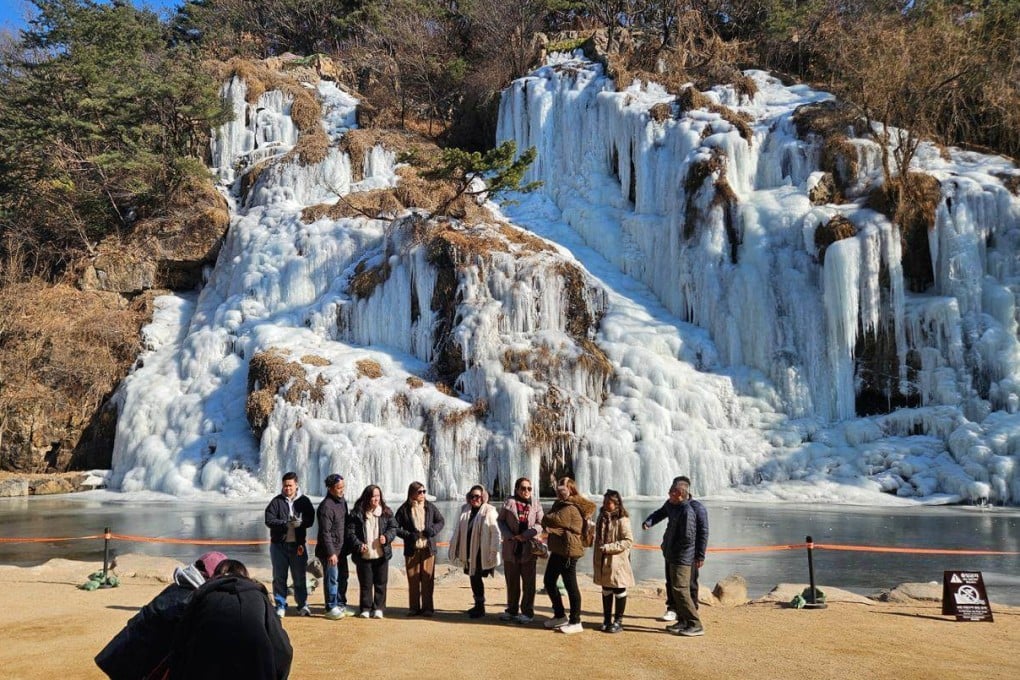 Filipino tourists pose for a photo in front of Hongje Falls in the Seodaemun district on February 9. Photo: The Korea Times