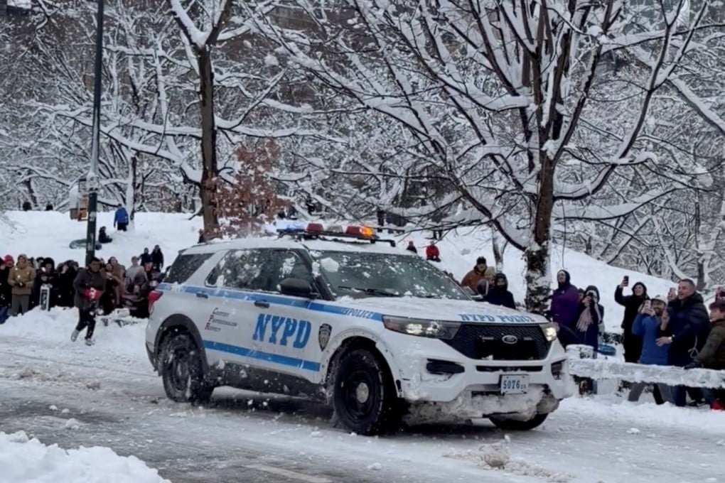 People throw snowballs at a New York Police Department car in Central Park on Monday. Photo: Maira Ahmad via Reuters