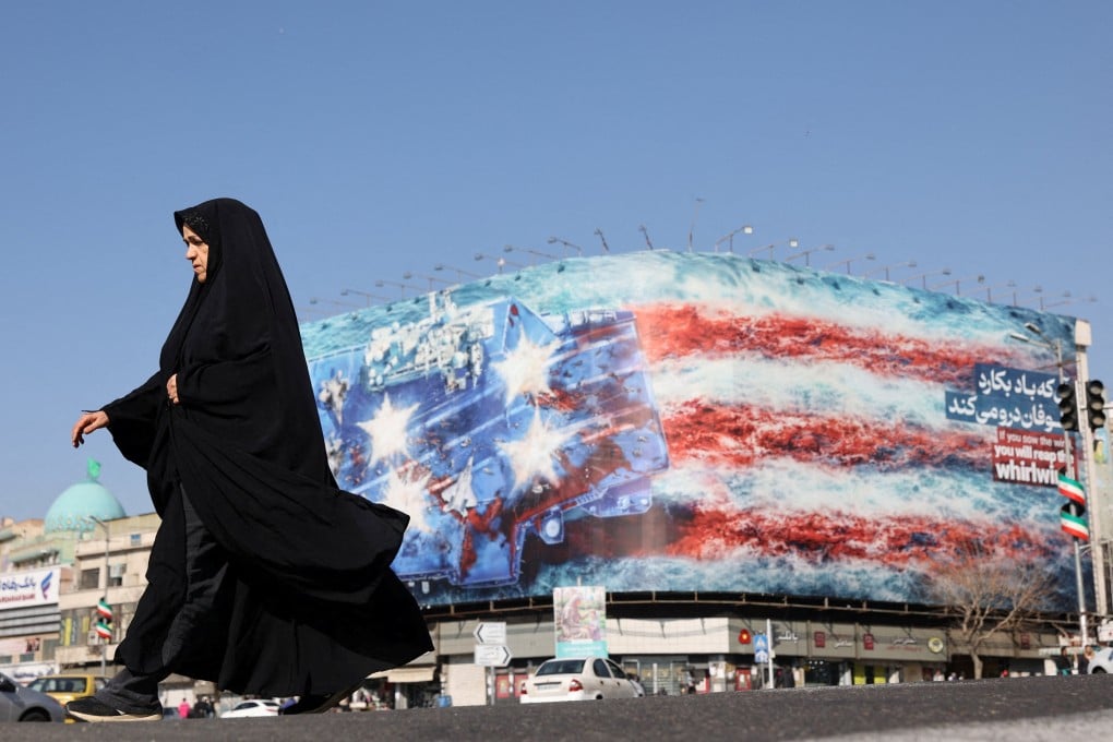 An Iranian woman walks past an anti-US billboard in Tehran. Photo: West Asia News Agency via Reuters