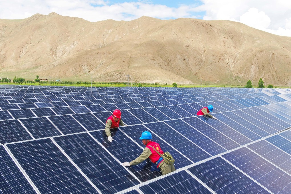 Maintenance staff check solar panels at a power generation facility in China’s Tibet autonomous region. Photo: Getty Images