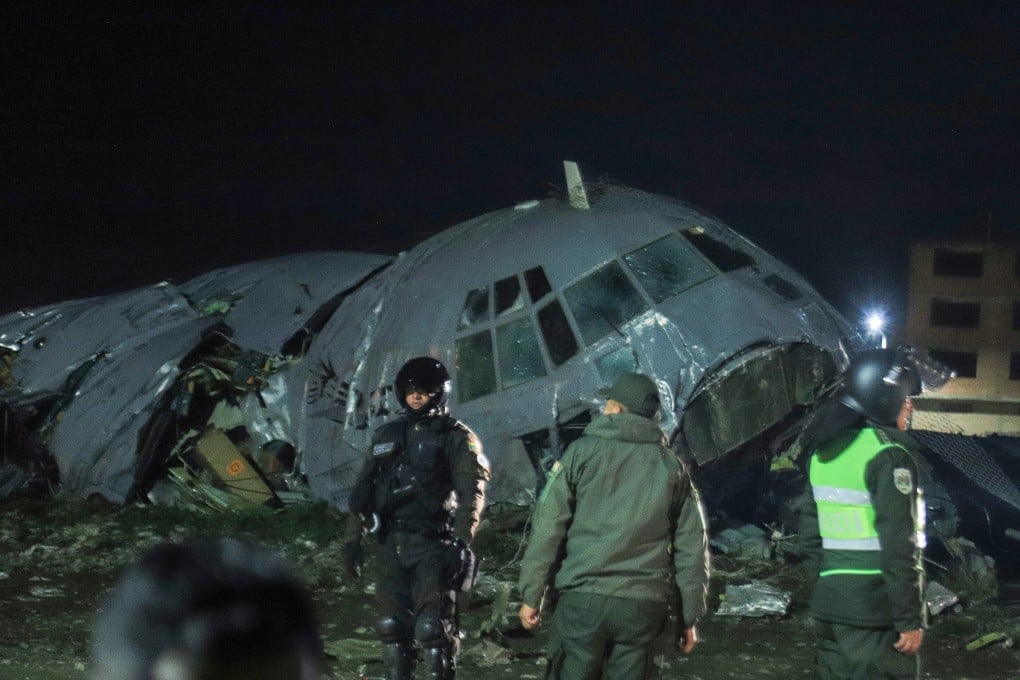 Bolivian military personnel guard the wreckage of a military cargo plane that crashed in El Alto, Bolivia, on Friday. Photo: EPA