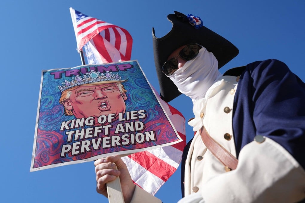 A person wearing an old military uniform and holding an anti-Trump sign takes part in a “March 4 Democracy” protest in Washington on Saturday. Photo: AFP