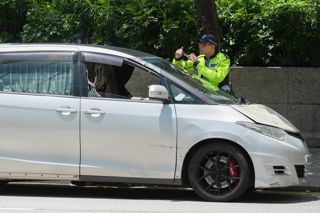 A police officer issues a traffic ticket to a driver in Wan Chai. In 2025, the force issued 2.068 million illegal parking penalty tickets, Photo: Eugene Lee