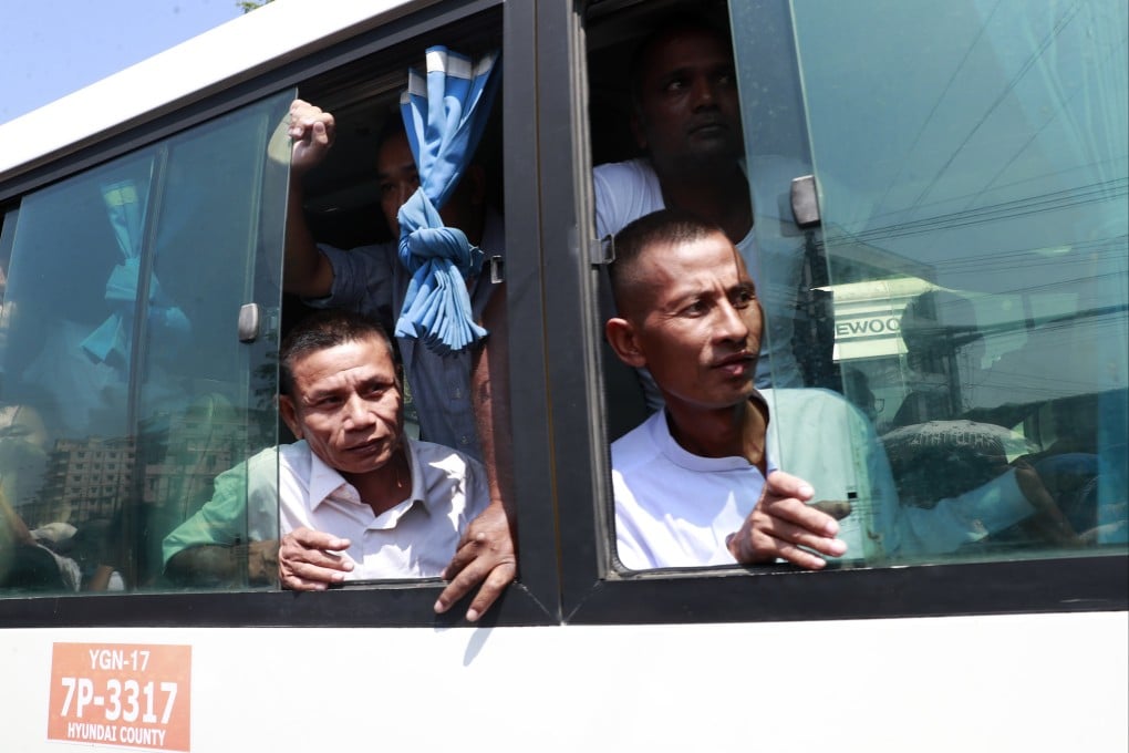 Released prisoners look from a bus window outside Insein Prison in Yangon, Myanmar, on Monday. Photo: EPA-EFE