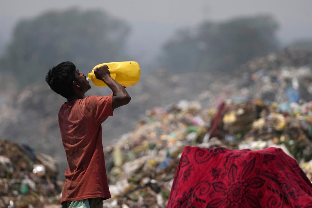 A waste picker drinks water while working at a rubbish dump on the outskirts of Jammu, India, during a heatwave in 2024. Photo: AP