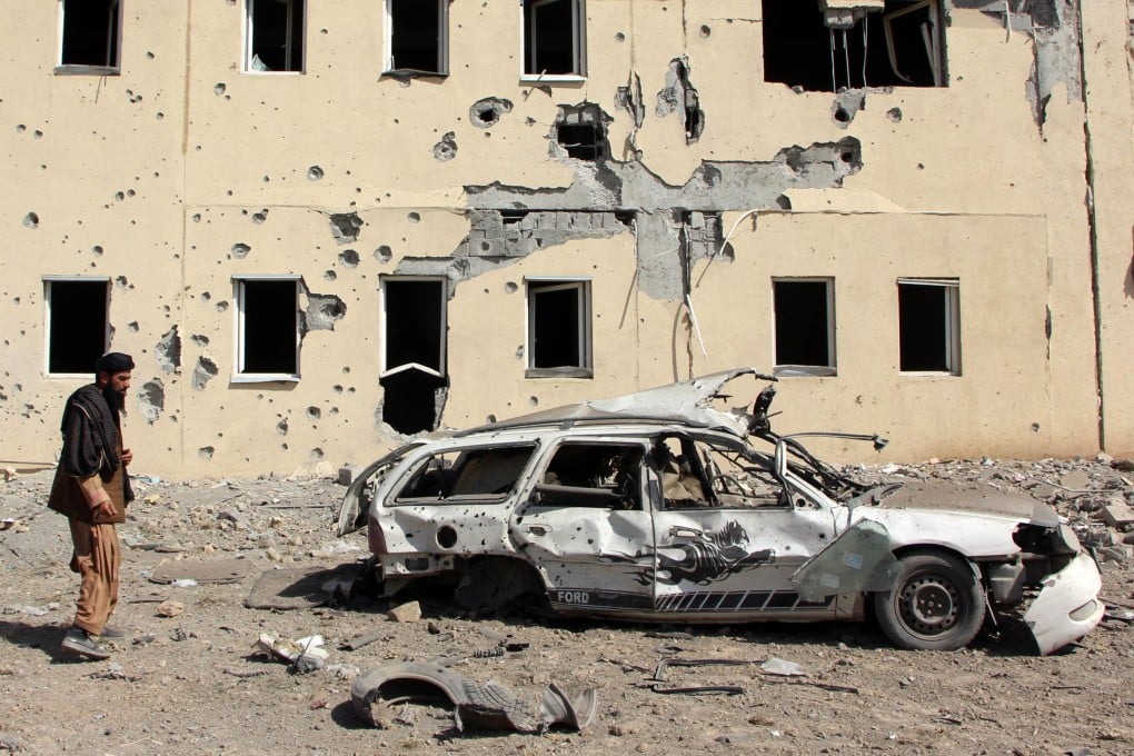 People survey a house that was damaged in the cross-border clashes between Pakistan and Afghanistan, in the Takhta-e-Pul district of Kandahar province, Afghanistan, on February 28. Photo: EPA
