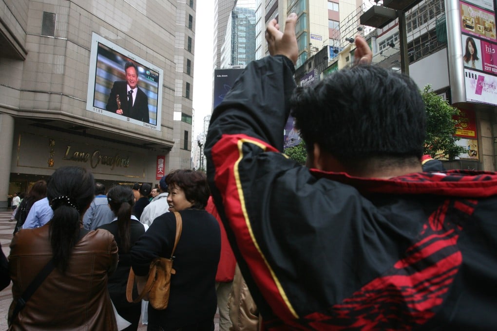 People watch on a large TV screen outside Hong Kong’s Times Square on March 6, 2006, as director Ang Lee accepts the Oscar for best director. Photo: SCMP