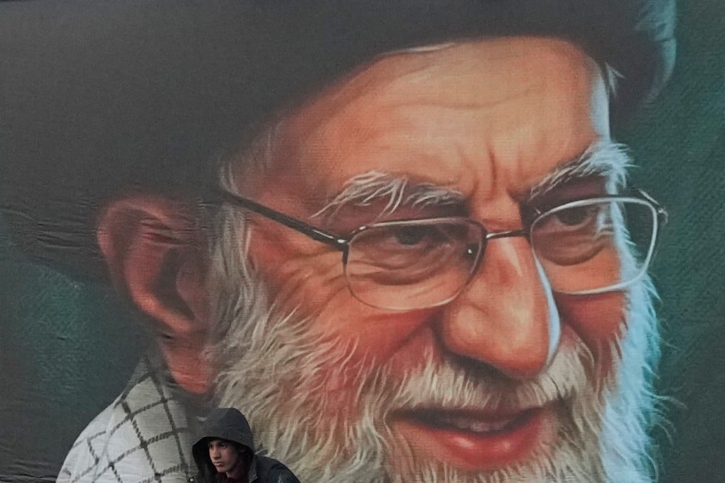 A worker installs a billboard on a Tehran overpass containing a portrait of the late Iranian Supreme leader Ayatollah Ali Khamenei. Photo: AP