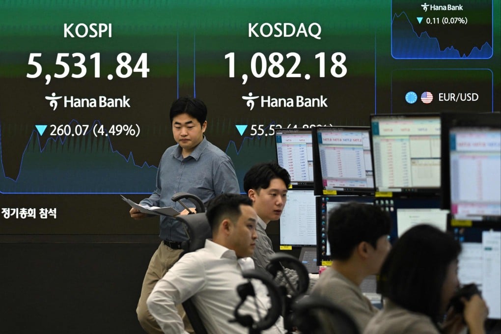 Currency dealers monitor exchange rates as an electronic screen shows South Korea’s benchmark stock index on Wednesday. Photo: AFP