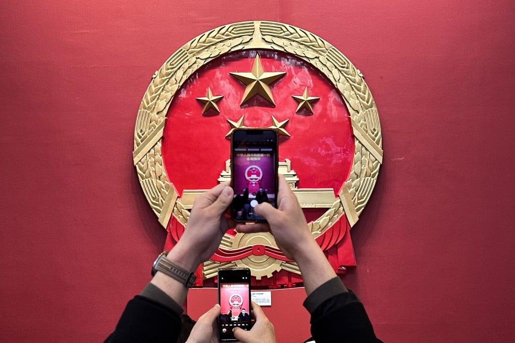 Visitors take photos of the life-size replica of China’s first metal national emblem at the National Museum of China in Beijing on March 3. Photo: Robert Ng