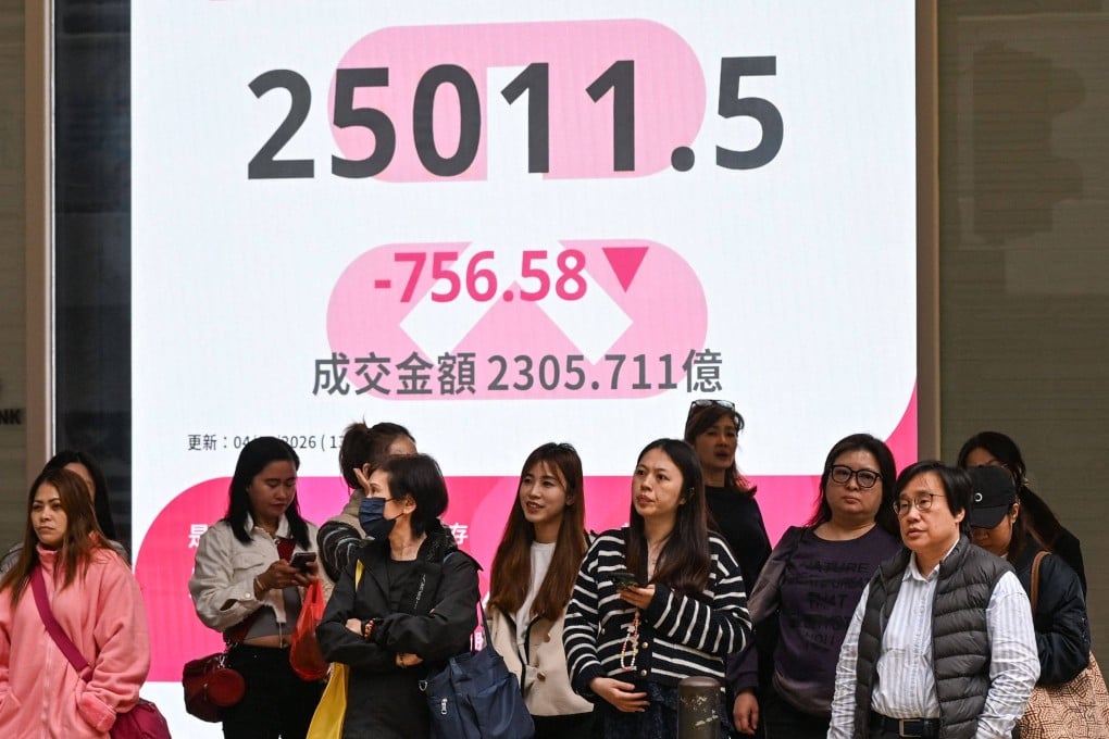 People wait to cross a road in front of an electronic display showing the Hang Seng Index in Hong Kong on March 4, as the US-Israel war in Iran sent oil prices rising. Photo: AFP