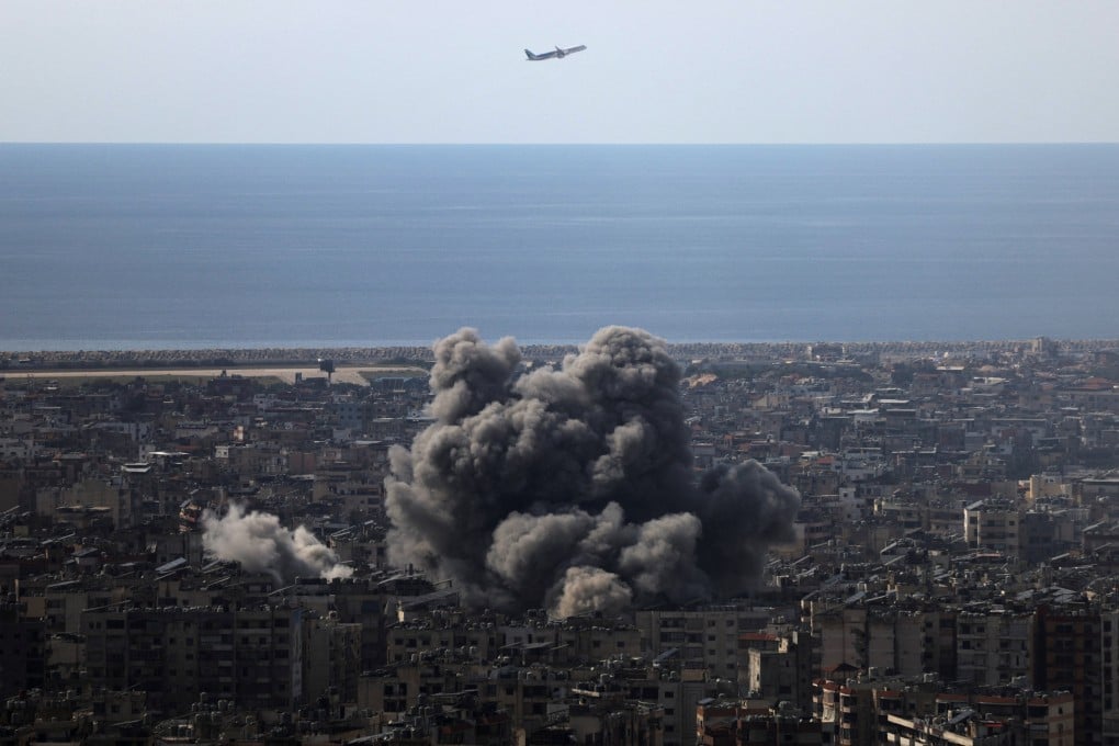 A plane flies as smoke rises after an Israeli strike on Beirut’s southern suburbs on Friday. Photo: Reuters